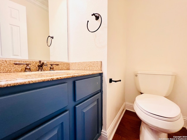 bathroom featuring crown molding, vanity, wood-type flooring, and toilet