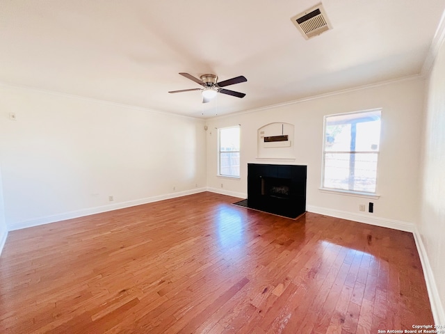 unfurnished living room featuring hardwood / wood-style flooring, plenty of natural light, and crown molding