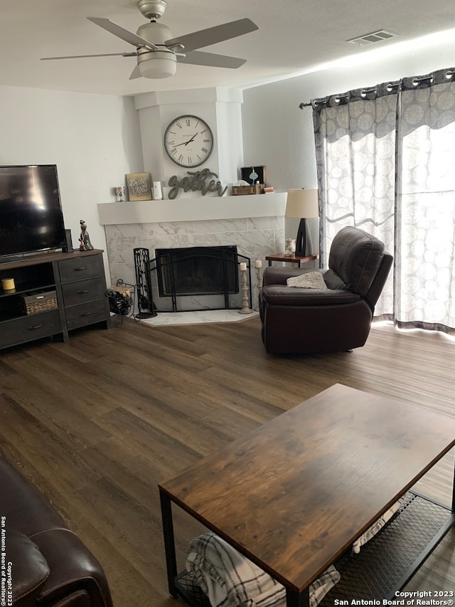 living room with ceiling fan, a fireplace, and wood-type flooring