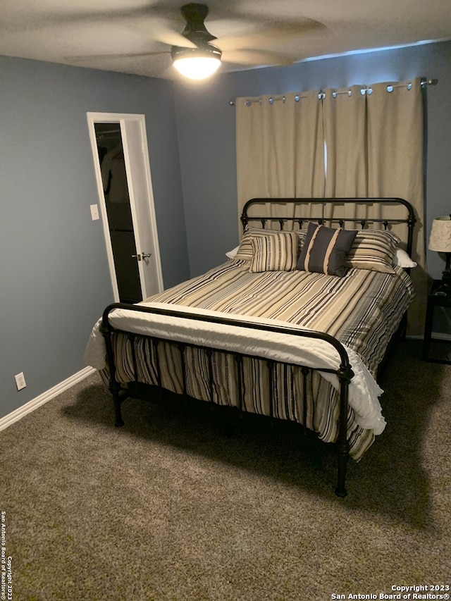 carpeted bedroom featuring ceiling fan and a spacious closet