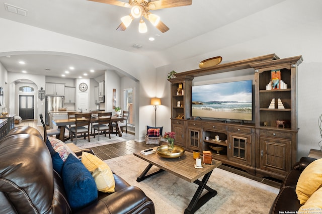 living room with ceiling fan, plenty of natural light, vaulted ceiling, and light wood-type flooring