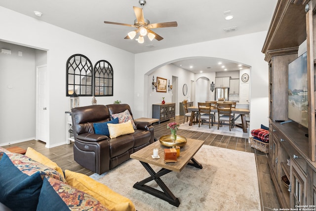 living room with dark hardwood / wood-style flooring and ceiling fan