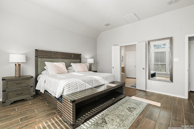 bedroom with vaulted ceiling and dark wood-type flooring