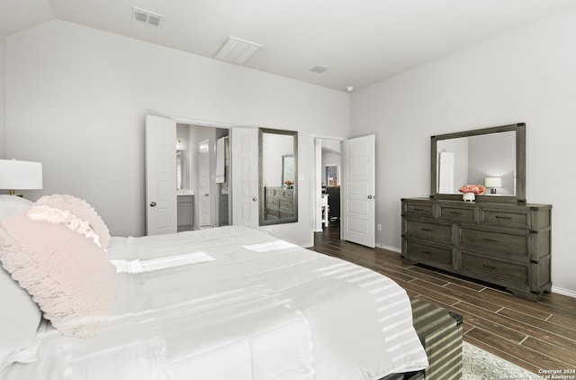 bedroom featuring ensuite bathroom, lofted ceiling, and dark wood-type flooring