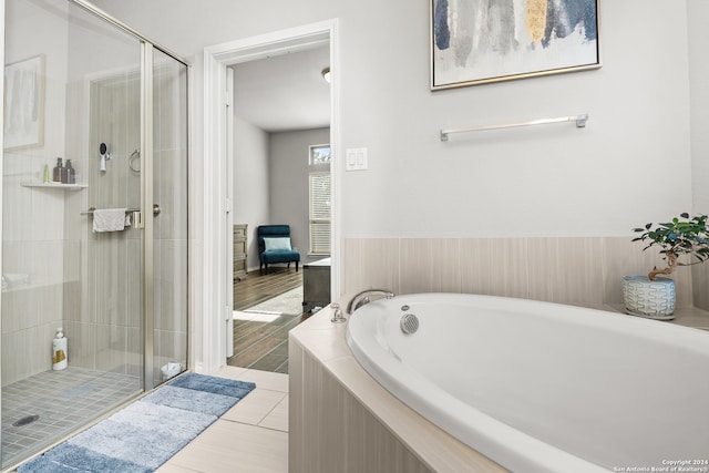 bathroom featuring separate shower and tub and wood-type flooring