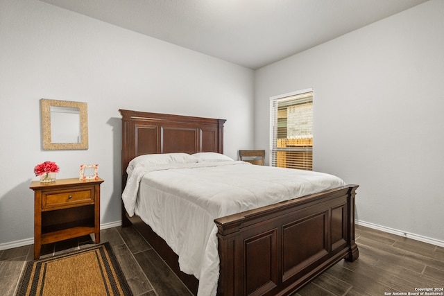 bedroom with dark hardwood / wood-style floors