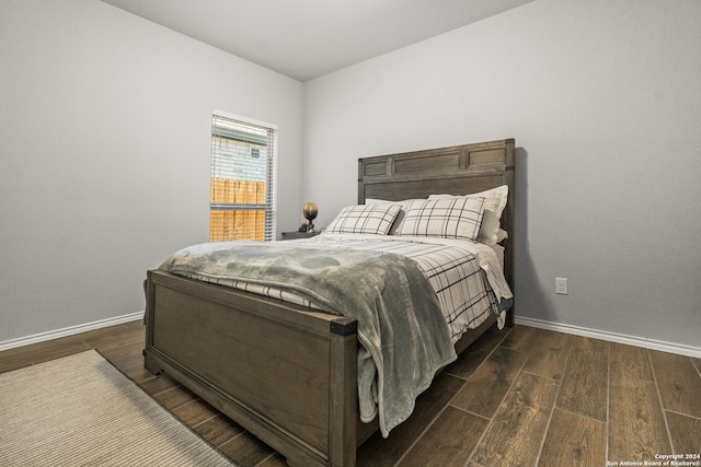 bedroom with dark hardwood / wood-style floors