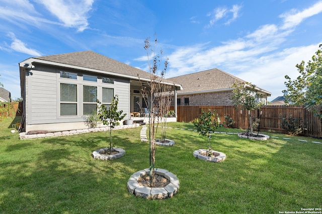 back of house featuring a yard and ceiling fan