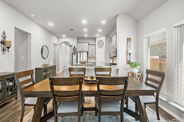 dining area featuring dark hardwood / wood-style flooring and vaulted ceiling