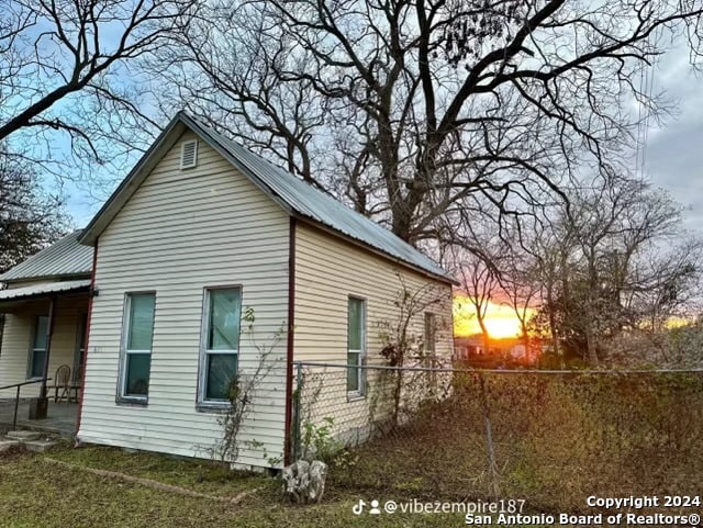 property exterior at dusk with a yard