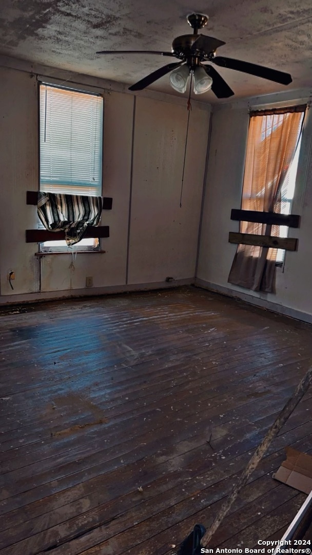 empty room featuring dark hardwood / wood-style flooring and ceiling fan