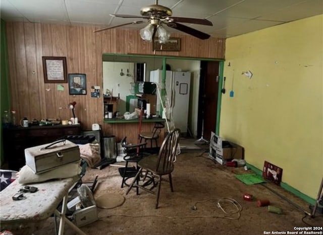 miscellaneous room with ceiling fan and wooden walls