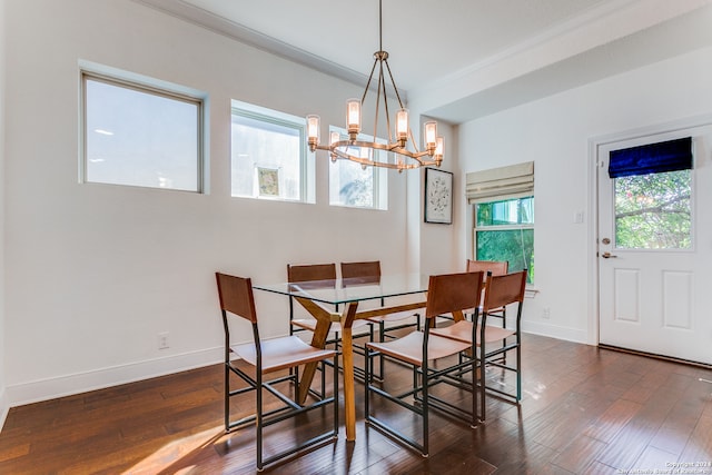 dining room featuring dark hardwood / wood-style flooring, plenty of natural light, ornamental molding, and a notable chandelier