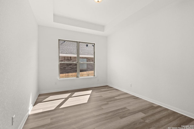 2612 Sueno Pt, San Antonio, TX 78245 - unfurnished room featuring wood finished floors, baseboards, and a tray ceiling