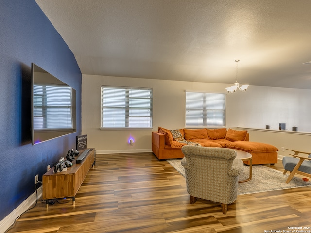 living room featuring dark hardwood / wood-style floors, a textured ceiling, and a chandelier