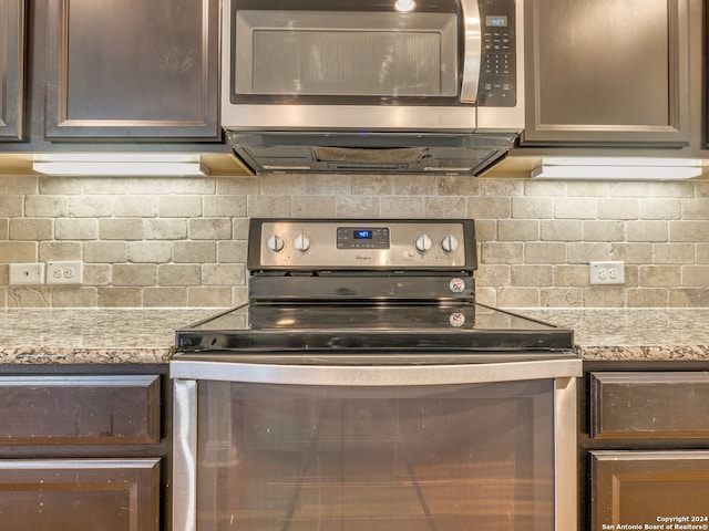 kitchen featuring light stone countertops, appliances with stainless steel finishes, backsplash, and dark brown cabinetry