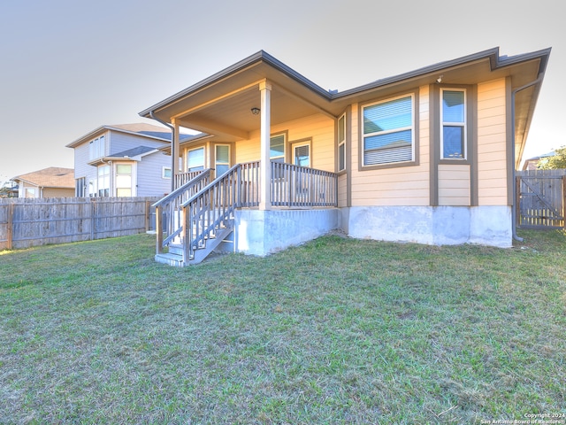 rear view of property with a lawn