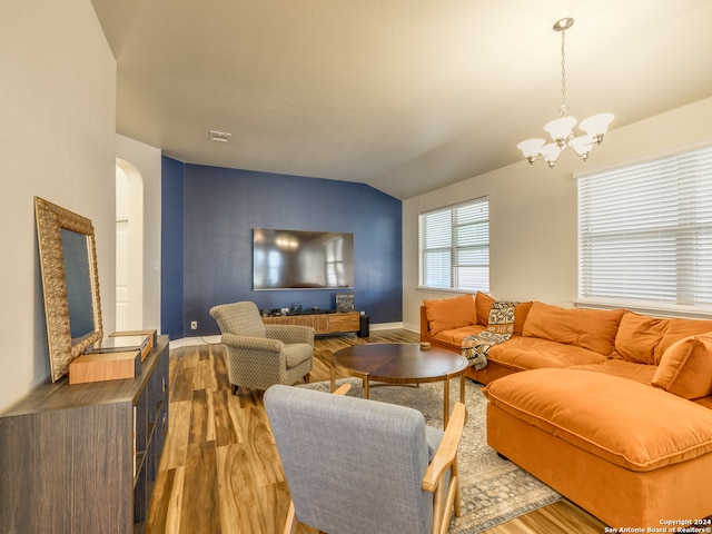 living room featuring hardwood / wood-style floors, a chandelier, and lofted ceiling