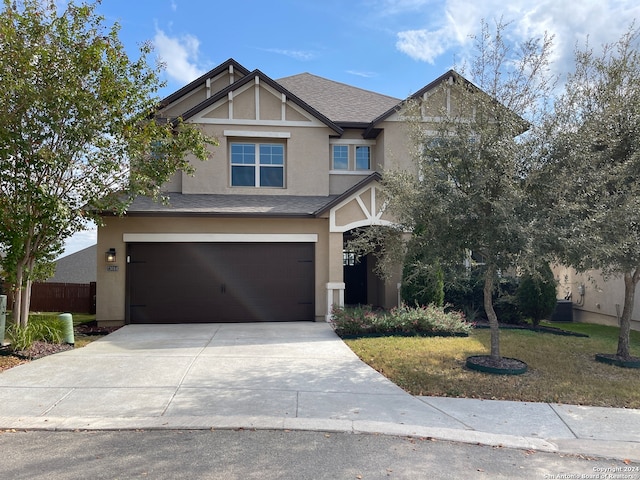 view of front facade with central AC, a garage, and a front lawn