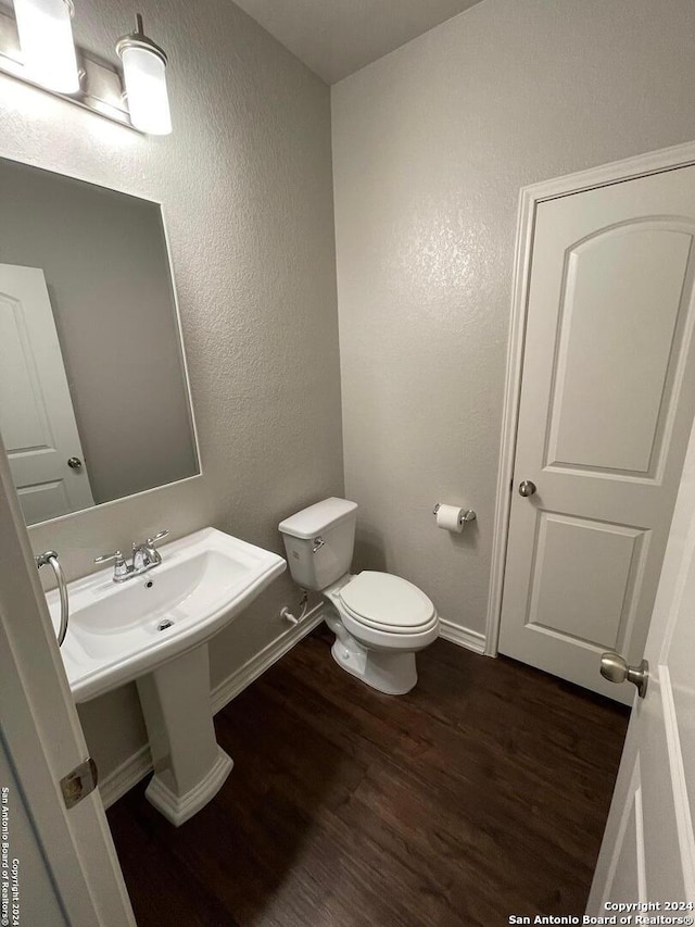 bathroom featuring hardwood / wood-style flooring and toilet