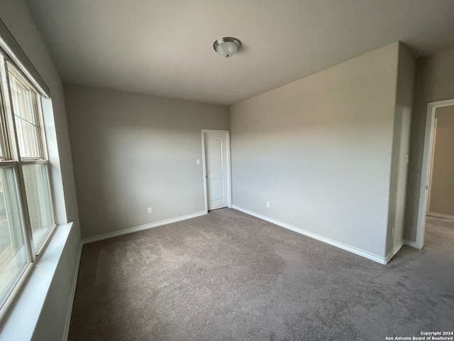 spare room with dark carpet