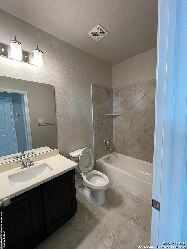 full bathroom with tiled shower / bath combo, tile patterned flooring, a textured ceiling, toilet, and vanity