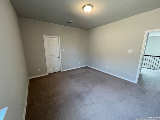 empty room featuring dark carpet