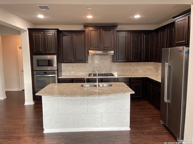 kitchen with dark wood-type flooring, sink, an island with sink, and stainless steel appliances