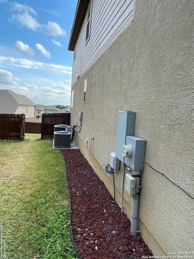 view of property exterior featuring a yard and central AC