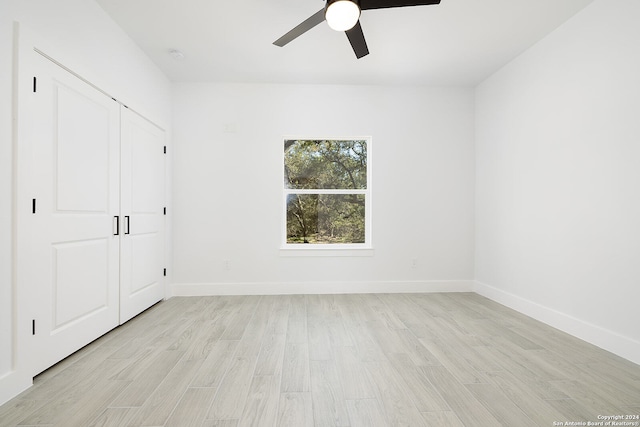 unfurnished bedroom featuring ceiling fan, light wood-type flooring, and a closet