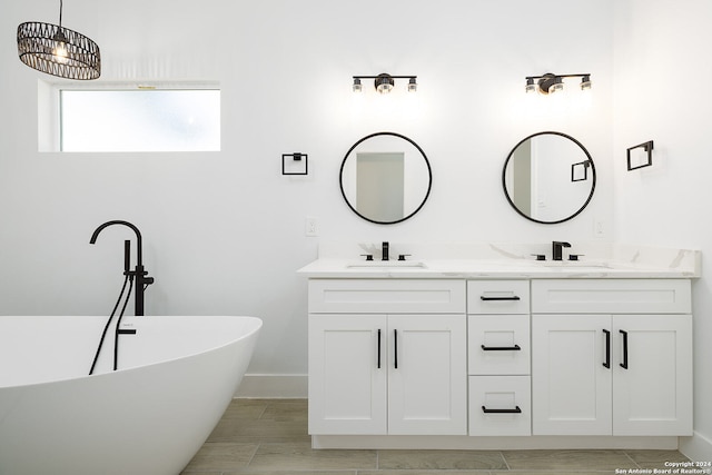 bathroom featuring a washtub and vanity