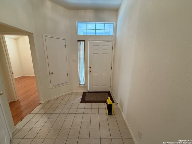 foyer with a towering ceiling and light hardwood / wood-style flooring