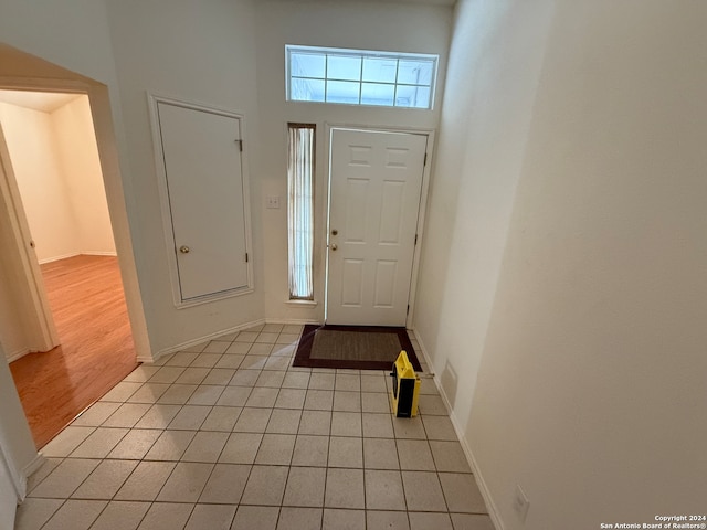 foyer entrance with light wood-type flooring and a high ceiling