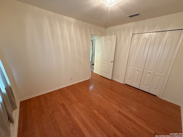 unfurnished bedroom with wood-type flooring and a closet