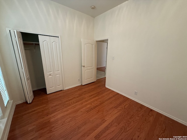 unfurnished bedroom with a closet and hardwood / wood-style floors