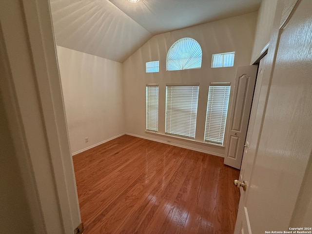 spare room with lofted ceiling and light wood-type flooring