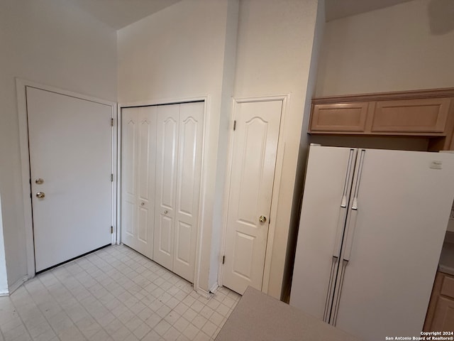 kitchen with light brown cabinets and white refrigerator