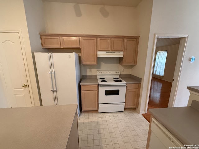 kitchen featuring light brown cabinets and white appliances