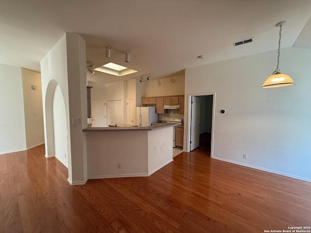 kitchen featuring electric range oven, white refrigerator, kitchen peninsula, hardwood / wood-style floors, and pendant lighting