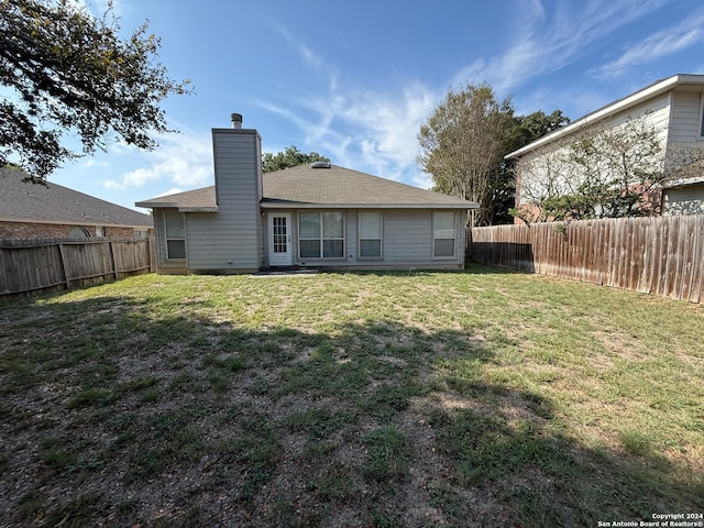 rear view of property with a yard