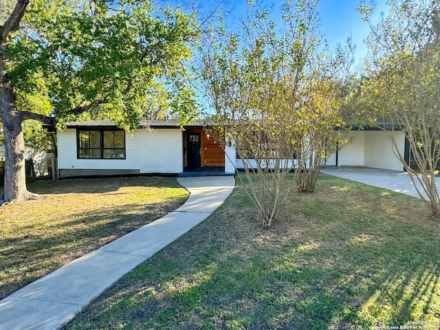 ranch-style house featuring a front yard and a carport