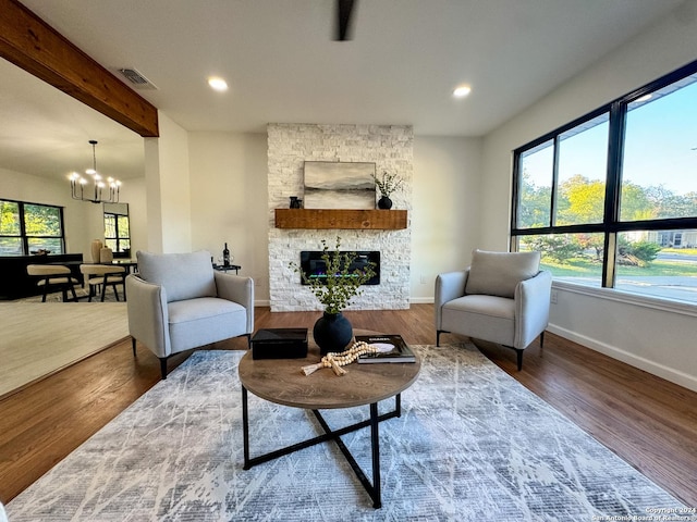 728 Rittiman, Terrell Hills, TX 78209 - living room featuring healthy amount of natural light, a chandelier, wood finished floors, a stone fireplace, and recessed lighting