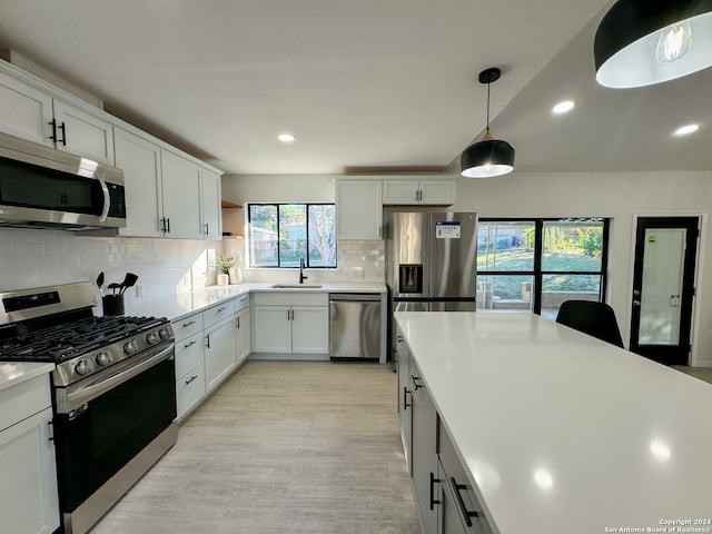 kitchen featuring backsplash, white cabinetry, sink, and appliances with stainless steel finishes