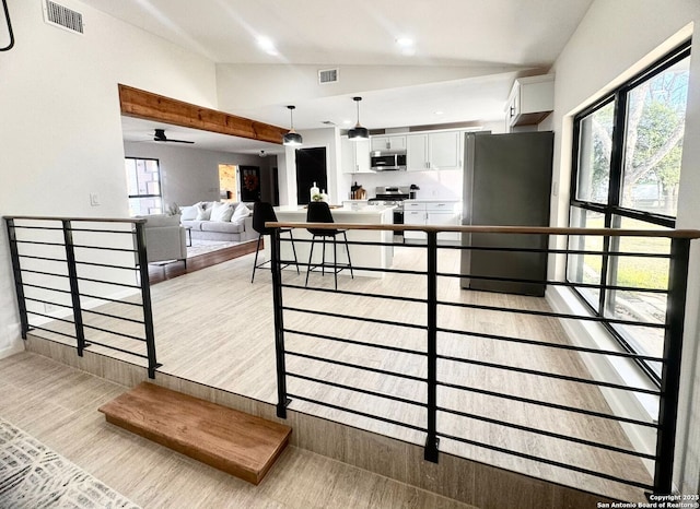 728 Rittiman, Terrell Hills, TX 78209 - kitchen with appliances with stainless steel finishes, lofted ceiling, white cabinetry, light wood-type flooring, and decorative light fixtures