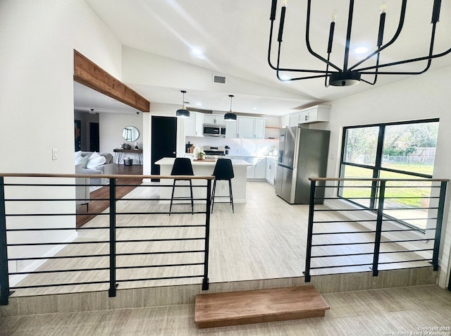 728 Rittiman, Terrell Hills, TX 78209 - kitchen featuring appliances with stainless steel finishes, lofted ceiling, white cabinetry, light countertops, and a chandelier