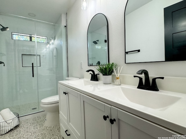 bathroom featuring tile patterned floors, vanity, toilet, and a shower with door