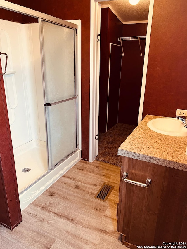 bathroom featuring hardwood / wood-style floors, vanity, and walk in shower