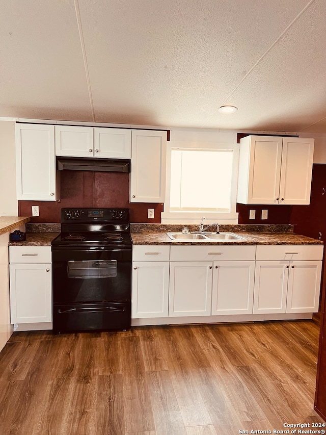 kitchen featuring a textured ceiling, sink, electric range, white cabinets, and hardwood / wood-style floors