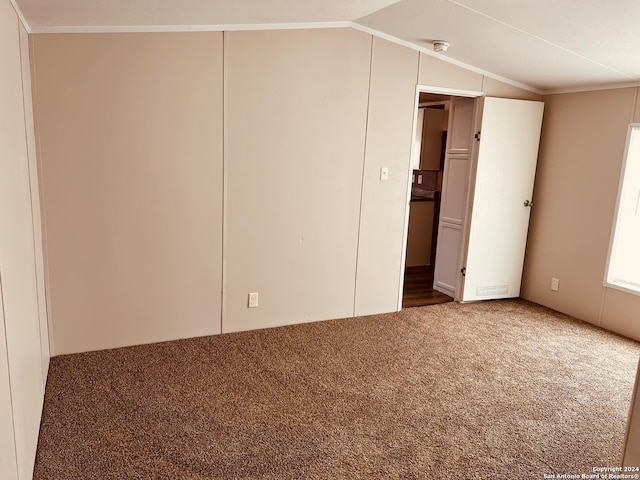 interior space with carpet flooring, lofted ceiling, and ornamental molding