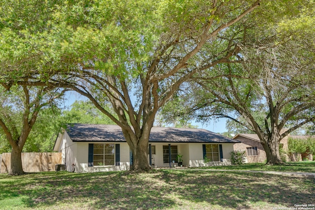 single story home with central AC unit and a front yard